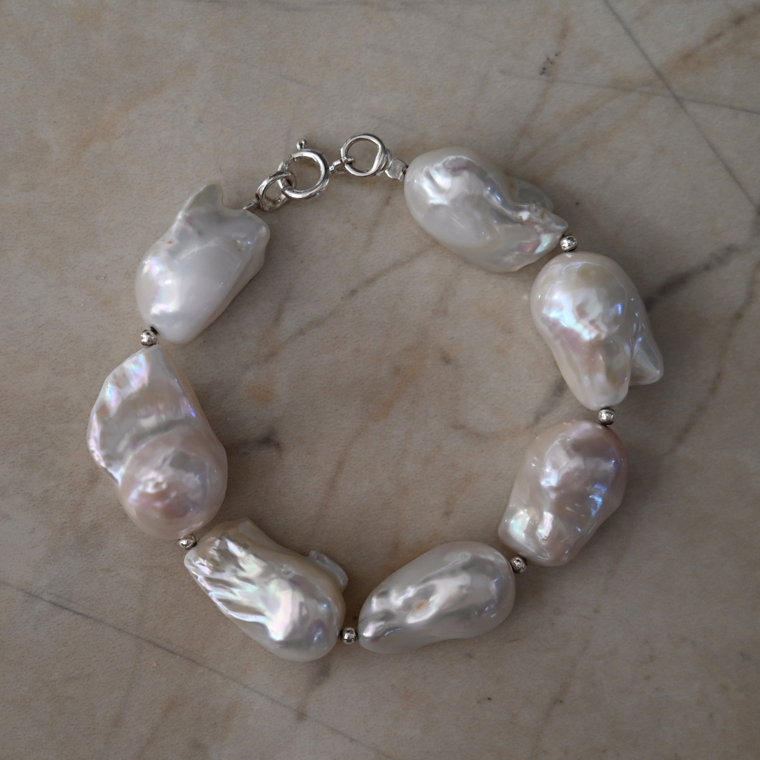 Big natural baroque Pearl bracelet on a marble surface
