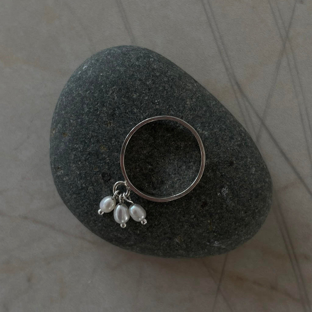 A womens silver ring with three dangling freshwater pearls