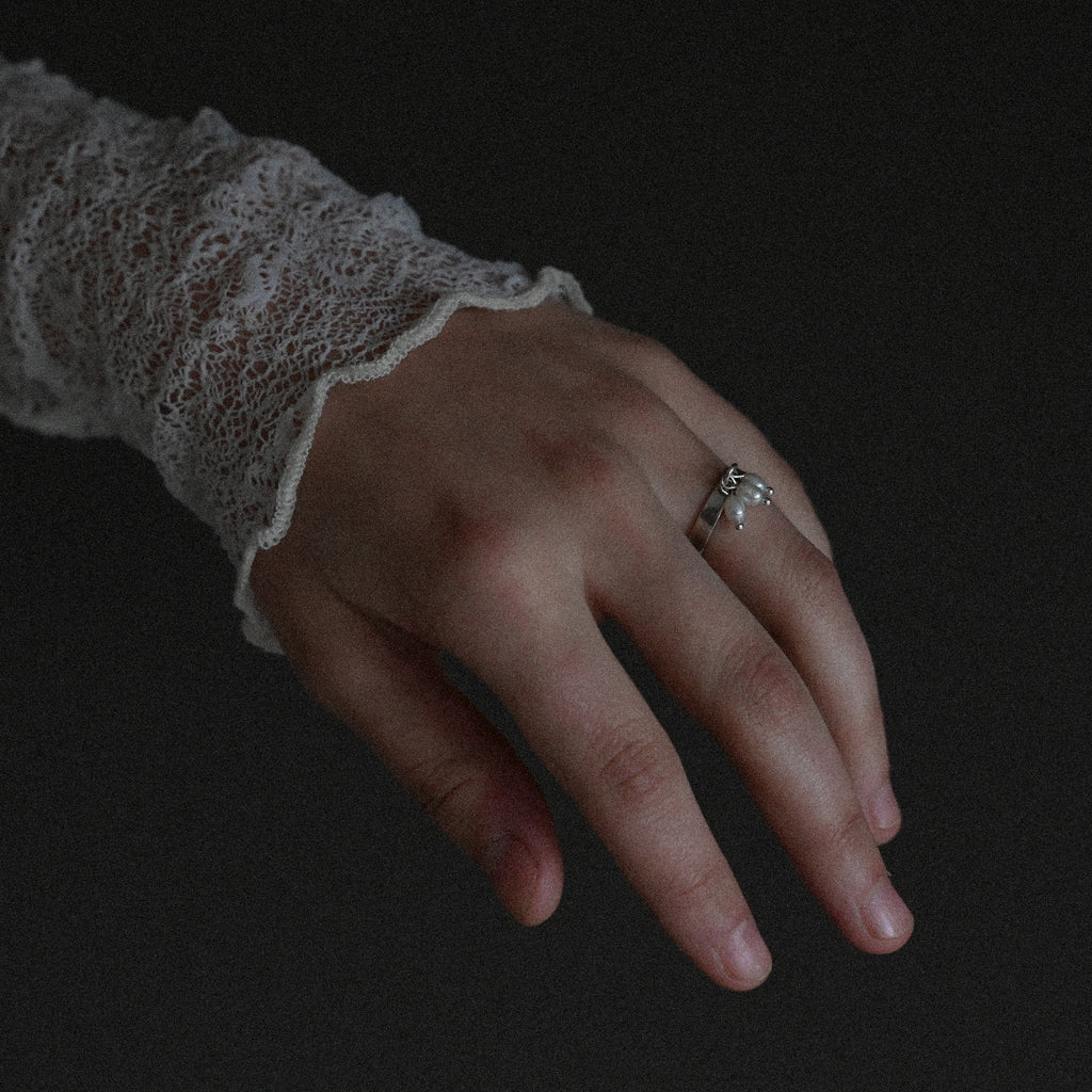 Hand wearing sterling silver small pearl ring
