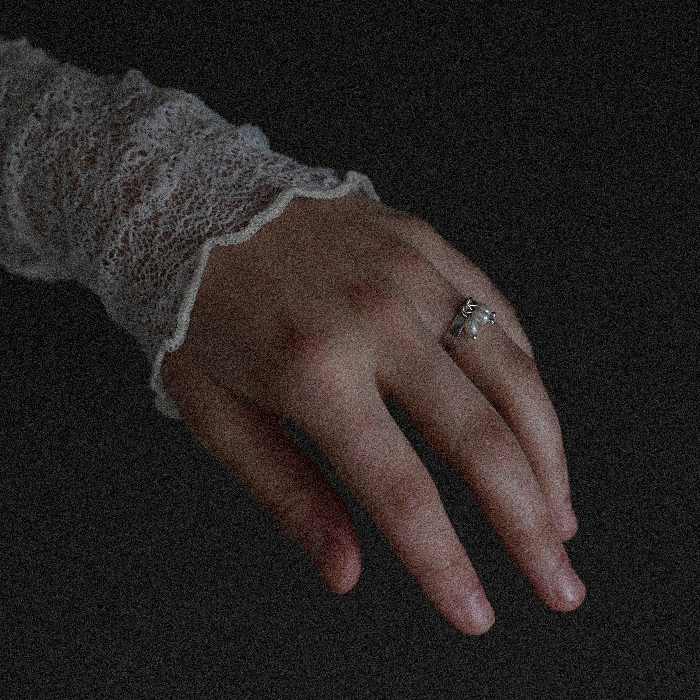 Hand wearing sterling silver small pearl ring