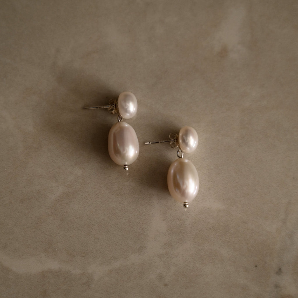 natural white freshwater pearl sterling silver earrings on a marble backgroud