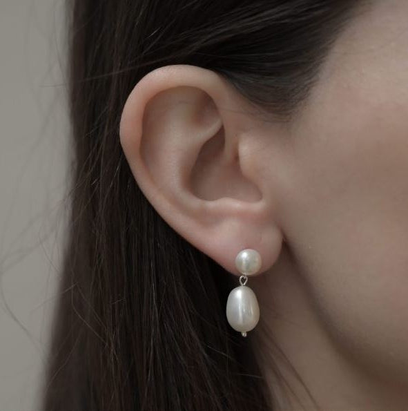 Woman wearing white natural pearl earrings