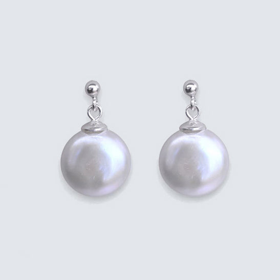 Pair of naturl white coin pearl earrings on a white background